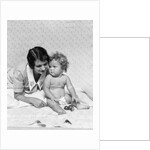 1920s 1930s woman mother lying sitting with baby on blanket by Anonymous