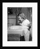 1950s little blond girl in pajamas standing at bathroom sink brushing her teeth toothpaste and toothbrush in hand by Anonymous