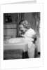1950s little blond girl in pajamas standing at bathroom sink brushing her teeth toothpaste and toothbrush in hand by Anonymous