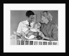 1950s smiling parents picking baby up out of crib by Anonymous