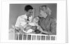 1950s smiling parents picking baby up out of crib by Anonymous