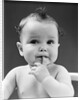 1940s thoughtful baby with finger in mouth by Anonymous