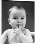 1940s thoughtful baby with finger in mouth by Anonymous