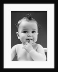 1940s thoughtful baby with finger in mouth by Anonymous