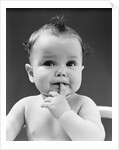 1940s thoughtful baby with finger in mouth by Anonymous