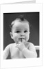 1940s thoughtful baby with finger in mouth by Anonymous