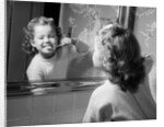 1950s girl looking in bathroom mirror brushing teeth by Anonymous