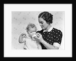 1930s woman mother giving baby daughter drink from mug by Anonymous