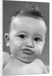 1950s baby making a funny face and bronx cheer noise looking at camera by Anonymous