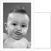 1950s baby making a funny face and bronx cheer noise looking at camera by Anonymous