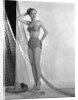 1950s glamour girl looking at camera posed in studio draped in fishing net wearing two piece bathing suit by Anonymous