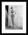1950s glamour girl looking at camera posed in studio draped in fishing net wearing two piece bathing suit by Anonymous