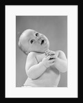 1950s baby in diaper head to one side arms hands clasped in front by Anonymous