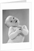 1950s baby in diaper head to one side arms hands clasped in front by Anonymous