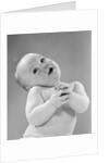 1950s baby in diaper head to one side arms hands clasped in front by Anonymous