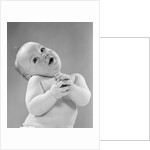 1950s baby in diaper head to one side arms hands clasped in front by Anonymous