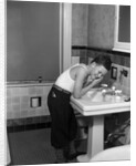 1930s boy washing face at bathroom sink by Anonymous