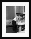 1930s boy washing face at bathroom sink by Anonymous