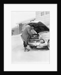 1950s man winter driveway trying to start fix car hood up by Anonymous