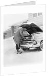 1950s man winter driveway trying to start fix car hood up by Anonymous