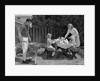 1960s man on patio grilling steak with 2 daughters seated at picnic table & wife standing serving food by Anonymous