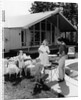 1950s family grilling hamburgers beside pool in backyard cookout by Anonymous