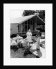 1950s family grilling hamburgers beside pool in backyard cookout by Anonymous