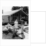 1950s family grilling hamburgers beside pool in backyard cookout by Anonymous