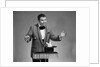 1960s man magician wearing tuxedo white rabbit peaking our of top hat by Anonymous