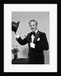 1970s smiling man magician wearing velvet tuxedo white gloves pointing magic wand at top hat looking at camera by Anonymous