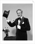 1970s smiling man magician wearing velvet tuxedo white gloves pointing magic wand at top hat looking at camera by Anonymous