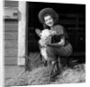 Girl posing with calf in straw filled stall in barn by Anonymous