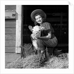 Girl posing with calf in straw filled stall in barn by Anonymous