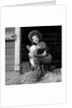 Girl posing with calf in straw filled stall in barn by Anonymous