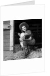 Girl posing with calf in straw filled stall in barn by Anonymous