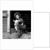 Girl posing with calf in straw filled stall in barn by Anonymous