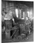 1930s elderly blacksmith with hammer at anvil as young boy holding harness looks on smiling by Anonymous