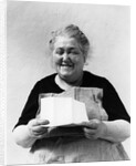 1930s 1940s elderly character woman smiling reading letter wearing apron looking at camera by Anonymous