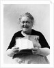 1930s 1940s elderly character woman smiling reading letter wearing apron looking at camera by Anonymous
