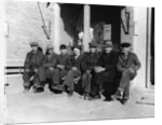 1920s 1930s group of old men in hats & dungarees sitting on bench in front of store window looking at camera by Anonymous