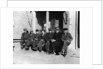 1920s 1930s group of old men in hats & dungarees sitting on bench in front of store window looking at camera by Anonymous