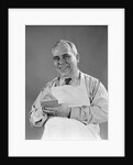 1940s man wearing white apron writing order on pad with pencil looking at camera by Anonymous