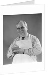 1940s man wearing white apron writing order on pad with pencil looking at camera by Anonymous