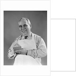 1940s man wearing white apron writing order on pad with pencil looking at camera by Anonymous