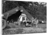 1920s couple man woman on fishing camping trip vacation at campsite man cooking over fire by Anonymous
