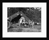 1920s couple man woman on fishing camping trip vacation at campsite man cooking over fire by Anonymous