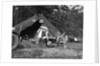 1920s couple man woman on fishing camping trip vacation at campsite man cooking over fire by Anonymous