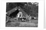 1920s couple man woman on fishing camping trip vacation at campsite man cooking over fire by Anonymous