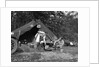 1920s couple man woman on fishing camping trip vacation at campsite man cooking over fire by Anonymous