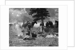 1920s 1930s two women at campsite woman cooking preparing food over campfire horses with riding gear in background by Anonymous